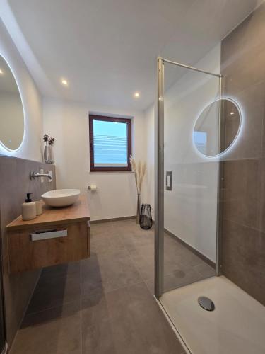 a bathroom with a glass shower and a sink at Ferienwohnungen Haus Daut in Willingen