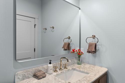 a bathroom with a sink and a large mirror at The Optimist Guesthouse | 3 in Camden