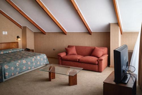una camera da letto con un letto, un divano e una TV di Hotel de Viña a Viña del Mar