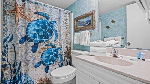 a bathroom with a blue turtle shower curtain at Romar Tower 1B in Orange Beach