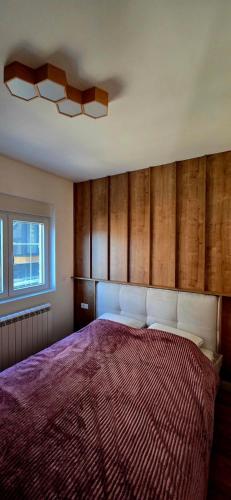 een slaapkamer met een groot bed en een raam bij North & South Escape Kolašin in Kolašin