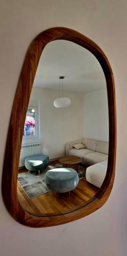 een woonkamer met een bank en een ronde spiegel bij North & South Escape Kolašin in Kolašin