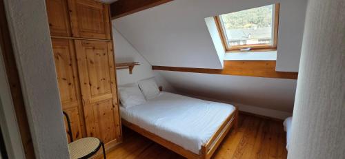 a small room with a bed and a window at duplex appartement 6 à 8 personnes in Guchan