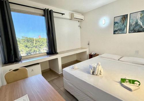 una camera con un letto, un tavolo e una finestra di Manacá Hotel a Foz do Iguaçu