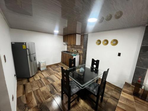 een keuken met een glazen tafel en een koelkast bij la terraza in Armenia