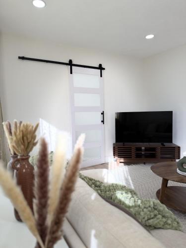 a living room with a tv and a couch at Stylish 3BR Revere Home Sleeps 8 Near Boston, Revere Beach and Airport in Revere