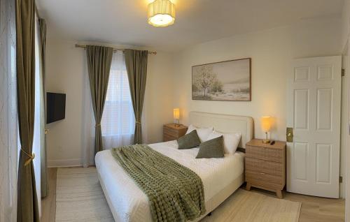 a bedroom with a bed with two lamps and a window at Stylish 3BR Revere Home Sleeps 8 Near Boston, Revere Beach and Airport in Revere