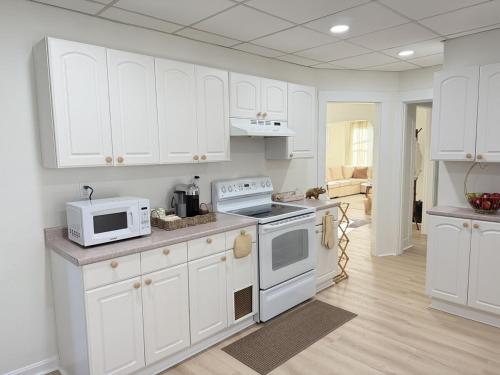 a kitchen with white cabinets and white appliances at Stylish 3BR Revere Home Sleeps 8 Near Boston, Revere Beach and Airport in Revere