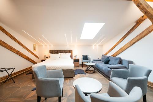 a bedroom with a bed and a couch and chairs at Stella Di Notte City Center Studios in Belgrade