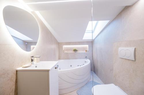 a bathroom with a white tub and a sink at Stella Di Notte City Center Studios in Belgrade