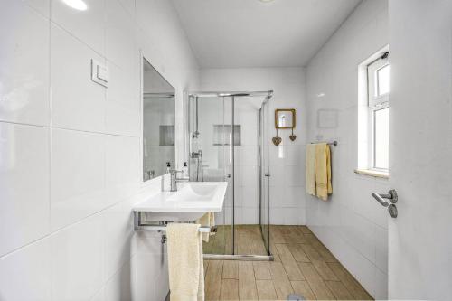 ein weißes Badezimmer mit Waschbecken und Dusche in der Unterkunft Villa Casa Alice by Villa Plus in Carvoeiro