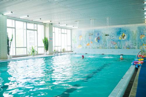 a large swimming pool with people in the water at Sanatorium Sosnovy Bor in Kholuy