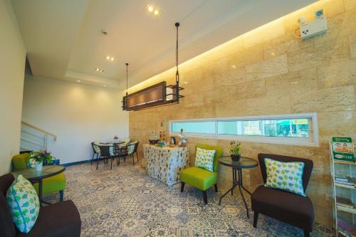 a lobby with chairs and tables and a wall at The Sila Hotel in Si Racha