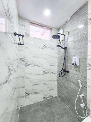 a bathroom with a shower with marble tiles at Raalhu Fonu Maldives in Mahibadhoo
