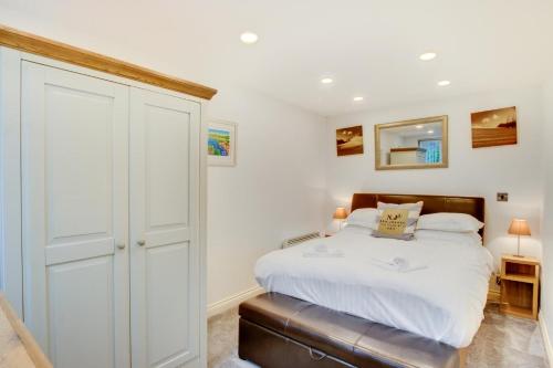 a white bedroom with a bed and a closet at 1 Bed in Limeslade oc-hh387 in The Mumbles
