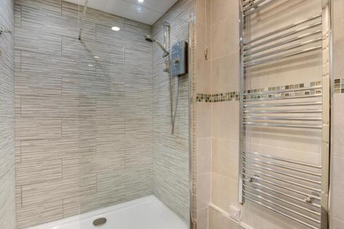 a shower with a glass door in a bathroom at 1 Bed in Limeslade oc-hh387 in The Mumbles