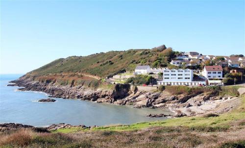 a group of houses on a hill next to the ocean at 1 Bed in Limeslade oc-hh387 in The Mumbles