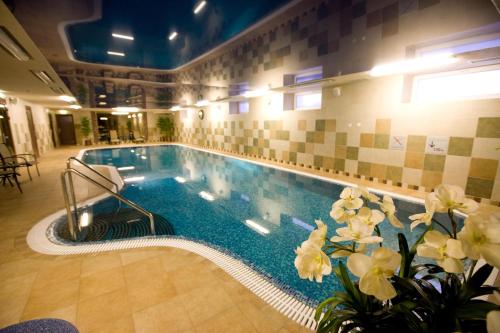 una piscina en un edificio con flores delante en Hotel Rocca al Mare en Tallin