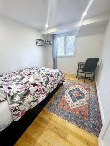 a bedroom with a bed and a chair and a rug at Private Bed Room in a Beautiful Family House in Brossard