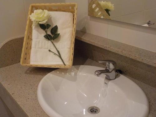 a bathroom sink with a vase of flowers on a towel at El Lagar De ElCiego in Elciego