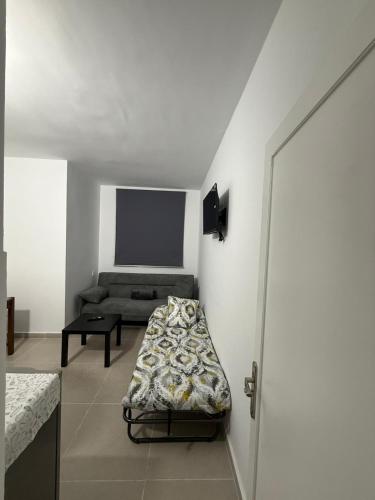 a living room with a bed and a couch at La posada del sur in San Bartolomé de Tirajana