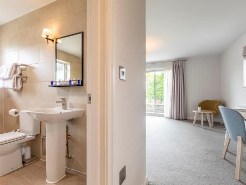 a bathroom with a sink and a toilet and a mirror at 3 Bed in Saltash oc-87717 in St. Mellion