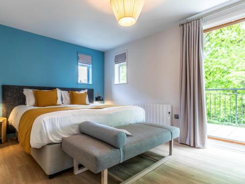 a bedroom with a large bed with a blue wall at 2 Bed in Saltash oc-87707 in St. Mellion
