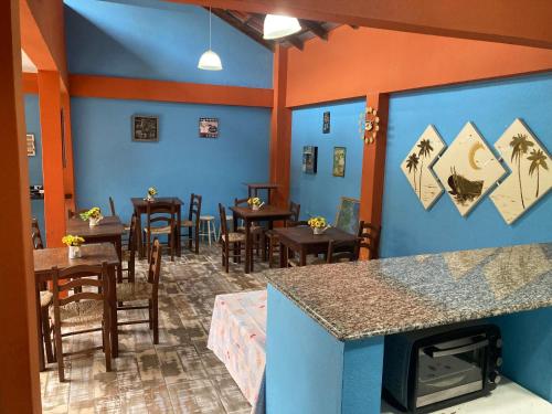 ein Restaurant mit Tischen und Stühlen und einem Kamin in der Unterkunft Pousada das Gaivotas in Bombinhas