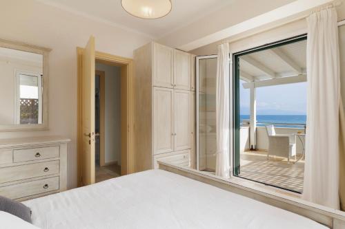 una camera da letto con un letto e vista sull'oceano di Beachfront Villa Victoras - With private beach a Sidari