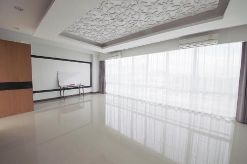 a large room with a projection screen and a podium at The Sila Hotel in Si Racha