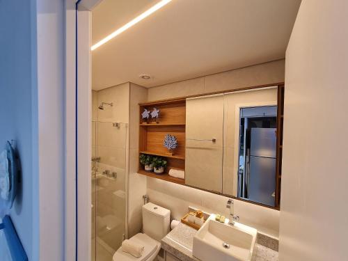 een badkamer met 2 toiletten, een wastafel en een spiegel bij Beach Class Summer in Porto De Galinhas