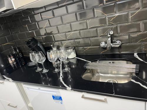 a kitchen counter with wine glasses and a sink at Sweet Dreams Apartment, estilo y confort en 1ª línea, Renovado, Práctico y Anfitrión 5 Estrellas" in Empuriabrava