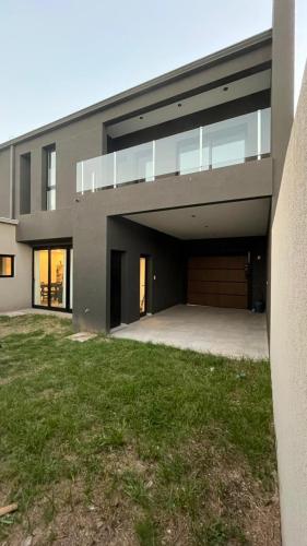 une grande maison avec un garage et une pelouse dans l'établissement Dúplex con Garage Esperanza, à Esperanza