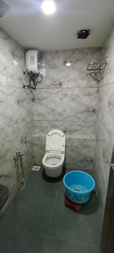 a bathroom with a toilet and a blue bowl at Hotel Nest View In in Ahmedabad