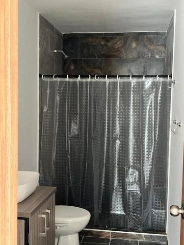 a bathroom with a shower curtain and a toilet at El Brillante in Ulloa