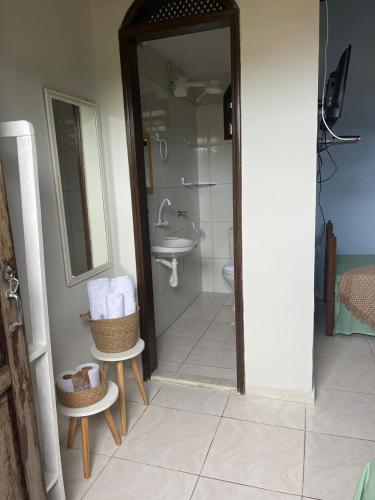 a bathroom with a shower and a toilet and a sink at Raízes Pousada in Porto Seguro