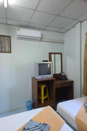 a room with a tv and a desk with two beds at Phang Nga Guesthouse in Phangnga