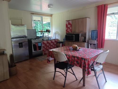 a kitchen with a table and chairs in a room at Fare vallée de Paopao in Paopao