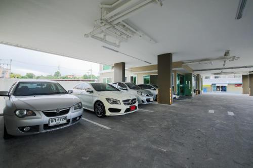 a row of parked cars in a parking lot at The Sila Hotel in Si Racha