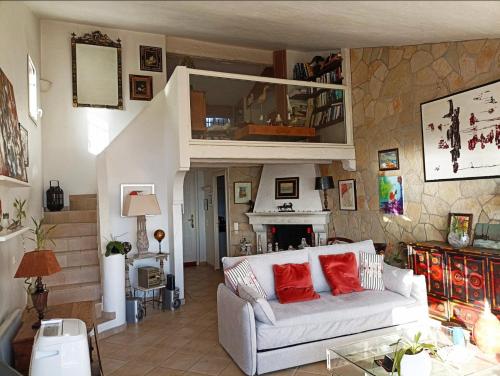 a living room with a white couch with red pillows at Paradis bleu in Agay - Saint Raphael