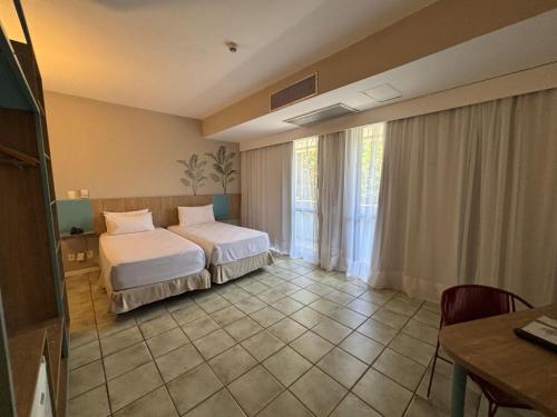 a hotel room with two beds and a window at Hotel Camarote Salvador in Salvador