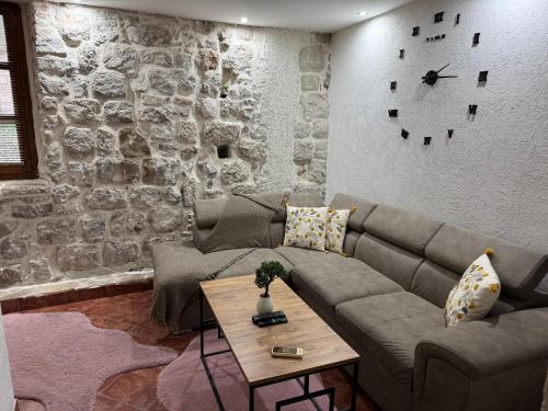 een woonkamer met een bank en een tafel bij Little bay apart 2 in Kotor
