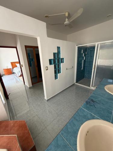a bathroom with two sinks and a cross on the wall at Casa Vemisa Puerto Escondido in Puerto Escondido