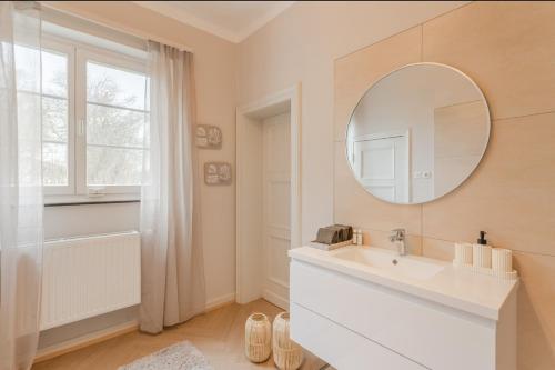 ein weißes Badezimmer mit Waschbecken und Spiegel in der Unterkunft Villa Vulkaneifel in Kelberg