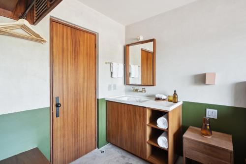 a bathroom with a sink and a mirror at ALMA Surf Lodge in Punta Mita