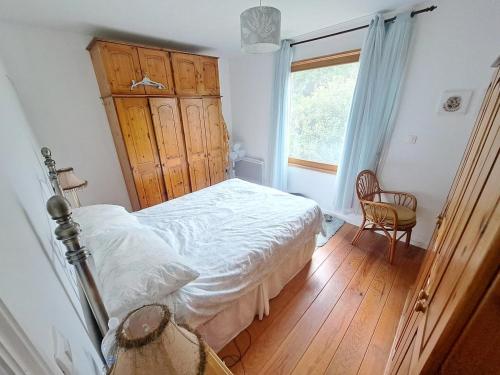 a bedroom with a white bed and a window at Le Châlet de l'Authie in Vitz-sur-Authie