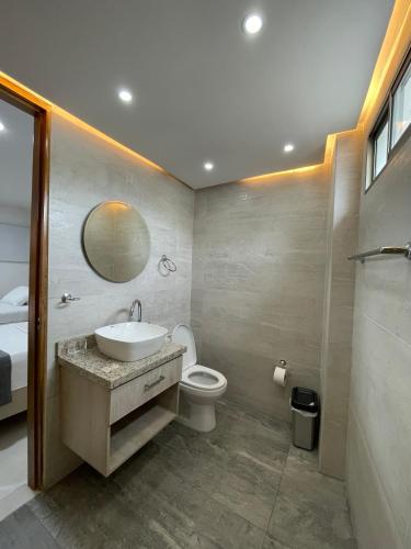 a bathroom with a sink and a toilet and a mirror at Hotel Ancor in Sincelejo