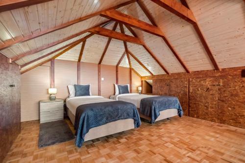 two beds in a room with wooden ceilings at Casa da Feira - Located in a peaceful Calheta area with sea views in Calheta