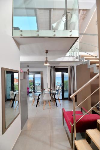 a living room with a staircase and a red couch at Seacret Apartments in Selianitika