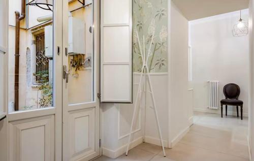 einen Flur mit einer weißen Tür und einem Stuhl in der Unterkunft Spàzio apartments Sangiuliano in Catania